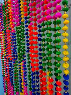 many different colored tassels hanging on a wall