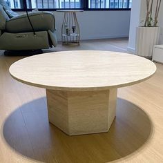 a round wooden table sitting on top of a hard wood floor