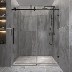 a walk in shower sitting next to a sink and a shelf with bottles on it