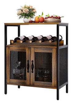 a wooden cabinet with glass doors and bottles on the top, next to a vase filled with flowers