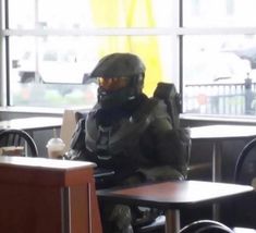 a man in a gas mask sitting at a table