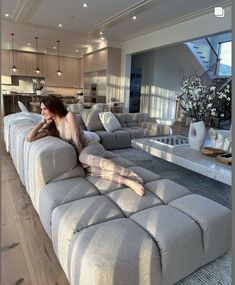 a woman laying on top of a couch in a living room