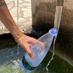 a person is pouring water from a faucet