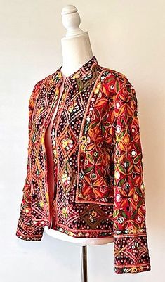 This exceptional cotton jacket with beautiful old embroidery is one-of-a-kind, collector's item. Fully embroidered on all sides, mixed colors which may be worn in all seasons. 3/4 sleeves, fully lined, open duster style. A traditional complex pattern is created from the embroidery. Designed to be worn open, easy fit. This jacket can be worn over a long silk tank dress, palazzo pants, slacks, skirt and even jeans. Jacket crafted by skilled Indian Guajarati Artisans. This jacket represents the true craftsmanship of the region and an object of art. It Is perfect for any event and great for travel. The traditional embroidery patterns are perfect for the boho look of the season. Consider purchasing for a special gift; wedding, anniversary, holiday, etc. One Size: Fits US size 8-12 (Medium) . Ch Traditional Winter Outerwear With Mirror Work, Red Folk Style Outerwear For Festivals, Traditional Embroidered Festive Outerwear, Traditional Festival Outerwear With Mirror Work, Folk Style Red Outerwear For Festivals, Red Cotton Outerwear For Festivals, Traditional Long Sleeve Outerwear With Mirror Work, Red Cotton Festival Outerwear, Traditional Embroidered Outerwear For Festivals