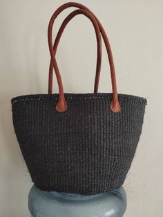 "A cosy and stylish black sisal and yarn bag. 10\" deep, 14\" wide sisal tote bag perfect for the beach/ summer bag. Comes with a leather handle 10\" long. DIMENSIONS Bottom width: 10\" Top width: 14\" Depth: 10\" Straps: 10\" SHIPPING All orders ship via DHL Express (3-5) days delivery time." Black Woven Satchel For Travel, Black Woven Bucket Bag With Double Handle, Black Handheld Beach Bag For Travel, Black Woven Bucket Shoulder Bag, Black Straw Bag For Daily Use With Large Capacity, Black Large Capacity Straw Bag For Daily Use, Black Straw Bag With Large Capacity For Daily Use, Black Woven Handheld Shoulder Bag, Black Large Capacity Straw Shoulder Bag