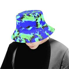 "Streetwear and rave inspired blue, green and black all over print paint splatter graffiti bucket hat by BigTexFunkadelic that is reversible; the flip side is solid black.. Made from premium cotton, this classic accessory adds another layer of cool to your outfit. * 9.00 Oz. Made from premium cotton. * Eyelets for breathability. * Size(approx): Brim: 2.44\", Side: 3.00\", Perimeter(top): 21.26\", Perimeter(brim): 34.65\". * Please wash it gently by hand for keeping its shape." Green Graffiti, Mens Bucket Hats, Paint Splatter, Green And Black, Black Light, Blue And Green, All Over Print, Solid Black, Caps Hats