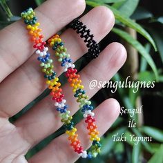 a hand is holding some colorful beaded bracelets