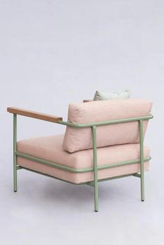 a pink and green chair sitting on top of a white floor