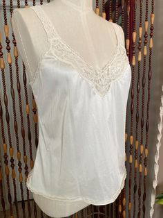 Sweet little cream colored camisole with stretchy lace straps. Brand is vanity fair, tag  says size 36/42, the dress form is an 8 and it is loose on it. Modern size large, or 10. it has some stretch. Lace V-neck Camisole, Cream Camisole With Built-in Bra And Spaghetti Straps, Coquette Camisole With Built-in Bra, Fitted Sleeveless Lace Camisole, Fitted Lace Camisole Sleeveless, Lace Top Camisole For Daywear, Chic Sheer Lace Camisole, Chic Fitted Camisole For Wedding Night, Chic Wedding Camisole With Lace Trim