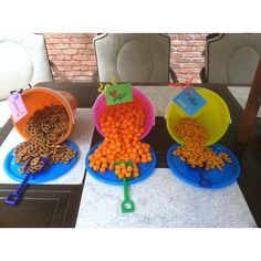 three buckets filled with different types of food sitting on top of a white table