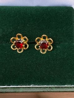 Vintage stud earrings made of 9ct gold, floral shape with garnets at the centre. Diameter 8mm. Yellow Gold Garnet Round Earrings, 14k Gold Round Flower Earrings For Formal Events, Formal Round Gemstone Flower Earrings, Yellow Gold Garnet Earrings For Anniversary, Gold Claddagh Ring, Vintage Stud Earrings, Tanzanite Diamond, Dream Board, Garnet Rings