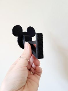 a person holding a mickey mouse shaped brush