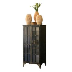 a tall cabinet with two vases on top of it