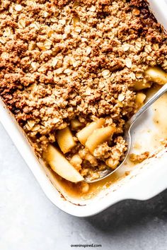 an apple crisp baked in a casserole dish with a spoon