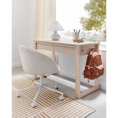 a white chair sitting next to a wooden desk with a backpack on top of it