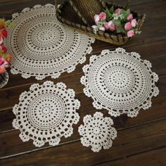 three doily are laying on the floor next to a basket with flowers in it