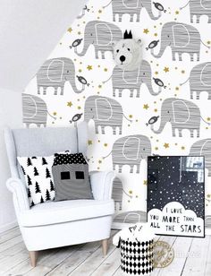 an elephant themed wallpaper in a living room with a chair and pictures on the floor