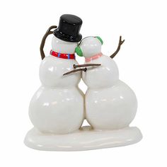 a couple of snowmen standing next to each other on top of a white surface