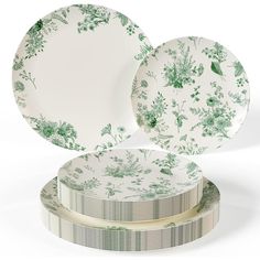 three plates sitting on top of each other in front of a white background with green flowers