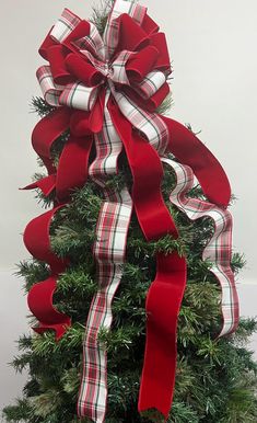 a christmas tree with red and white ribbons