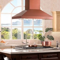 a kitchen with an oven, stove and pot on the counter top in front of a window