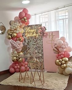 the balloon arch is decorated with pink, gold and white balloons