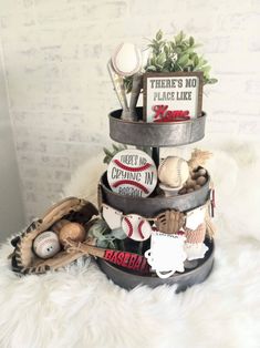 a baseball themed tiered cake is displayed on a white furnishing with the words there's no place like home