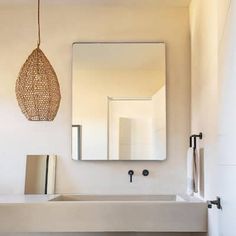 a bathroom with a sink, mirror and towel dispenser on the wall