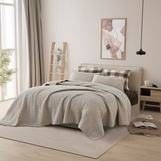 a bed room with a neatly made bed next to a window and a painting on the wall