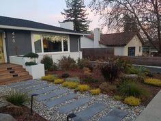 a house with stone steps leading to the front door and landscaping area next to it