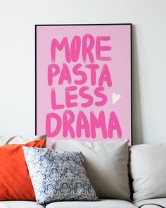 a pink poster with the words more pasta less drama on it above a white couch