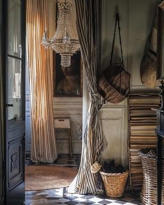 an old fashioned bedroom with striped curtains and a chandelier hanging from the ceiling