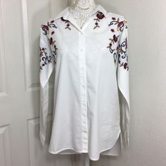 Cotton Button Up Shirt Featuring Embroidery Design Point Collar Long Sleeves Button Barrel Cuffs Split Hi-Lo Hem Back Yoke With Box Pleat Underarm To Underarm 21 Inches Front, Shoulder To Hemline 28 Inches Back, Shoulder To Hemline 30 Inches 100% Cotton Machine Wash Casual Button-up Blouse With Floral Embroidery, Casual Long Sleeve Blouse With Embroidered Cuffs, Spring Daywear Blouse With Embroidered Cuffs, Spring Blouse With Embroidered Cuffs For Daywear, Embroidered Cuffs Blouse For Spring Daywear, White Embroidered Long Sleeve Shirt, Spring White Embroidered Shirt, White Button-up Top With Floral Embroidery, White Embroidered Button-up Shirt