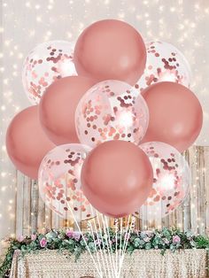 a bunch of balloons that are in front of a table with some lights on it