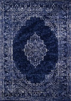 a blue rug with an intricate design on the middle and bottom, it is shown