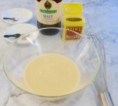 ingredients to make chocolate cake sitting on a marble counter top, including eggs and butter