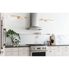 a kitchen with marble counter tops and white cabinets, along with an oven hood over the range