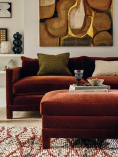 a living room filled with furniture and a painting on the wall above it's coffee table