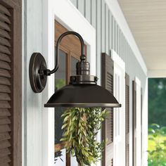 an outdoor light hanging from the side of a house