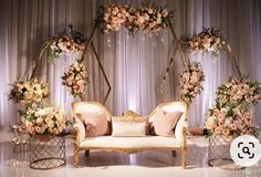 a couch with pillows and flowers on it sitting in front of a stage set up