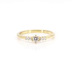 a yellow gold ring with three diamonds on it