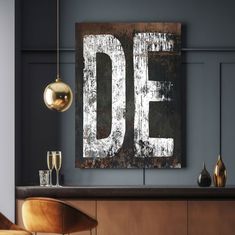 a wooden sign that says do hanging on the wall above a table with two glasses