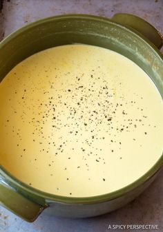 a green bowl filled with liquid on top of a table