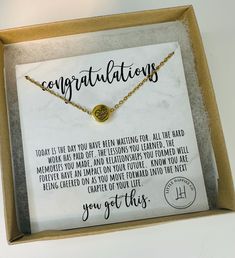 a box with a necklace in it that says congratulationss on the front and back