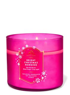 the bright pink candle has snowflakes on it and is lit in front of a white background