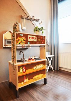 a wooden play kitchen in a child's room