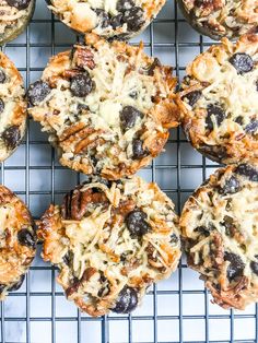 several muffins cooling on a wire rack with blueberries and pecans in the middle