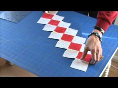 a person standing over a blue table with red and white squares on it