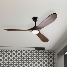 a ceiling fan mounted to the ceiling in a room with tiled walls and flooring