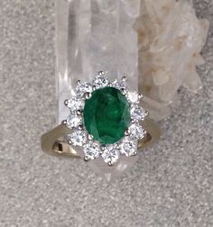 Gorgeous vintage diamond and Emerald ring. The diamonds in this 14k white gold ring total approximately .70 carats and grade out at FG color and VS2 clarity. The Vintage Natural Emerald is approximately 1 1/2 carats. As expected with a vintage emerald ring that has been lovingly worn for many years, there are some abrations and some small chips in the Emerald as you can see if you look closely at the photos. At this price You will love wearing this ring and treasure it for years to come. This ri Classic Green Halo Ring With Diamond Accents, Emerald Ring With Center Stone In 14k White Gold, 14k White Gold Emerald Cut Halo Ring, Oval Emerald Ring With Diamond Accents, Formal Diamond Ring With Prong-set Emeralds, Emerald Cut Diamond Cluster Ring For Anniversary, Gia Certified Dazzling Cluster Diamond Ring, Anniversary Diamond Cluster Ring With Emerald Cut, Timeless Diamond Emerald Ring For Anniversary